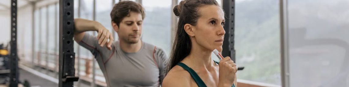 A fit couple engaged in gym exercises. Indoor workout with focus on fitness goals.